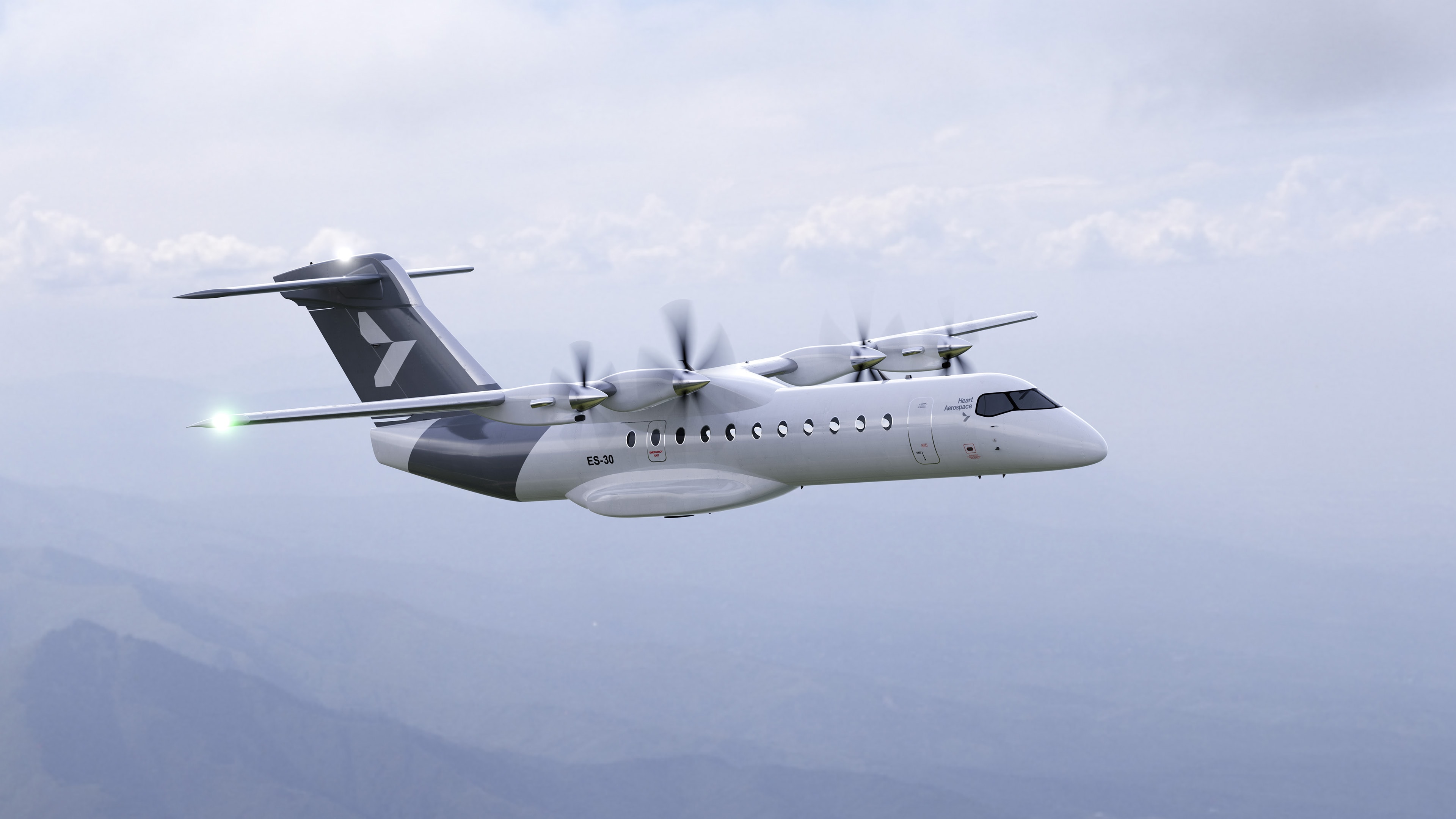 Heart Aerospace ES-30 hybrid-electric aircraft in cruise flight above a mountain range under a cloudy sky